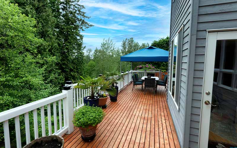 Modern bathroom with dark wood double vanity and white tub near a bedroom.