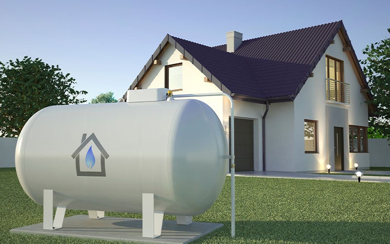 Large white above-ground propane tank in front of a house