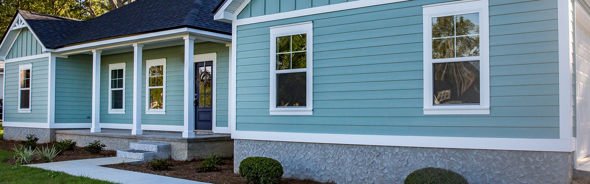 Modern A-frame cabin with large glass windows and outdoor jacuzzi