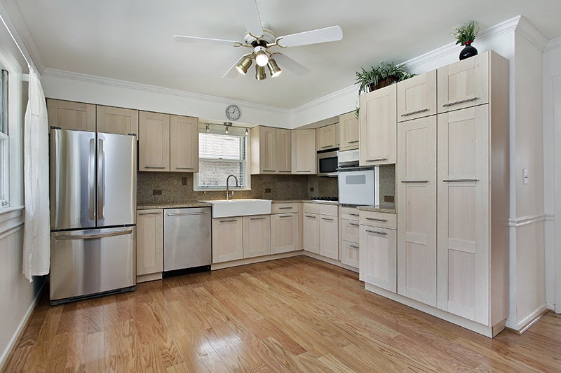 Light wood kitchen with stainless steel appliances and ceiling fan.