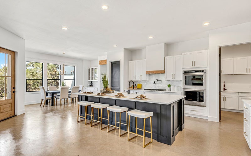 Modern kitchen with dark island and white cabinets, open concept