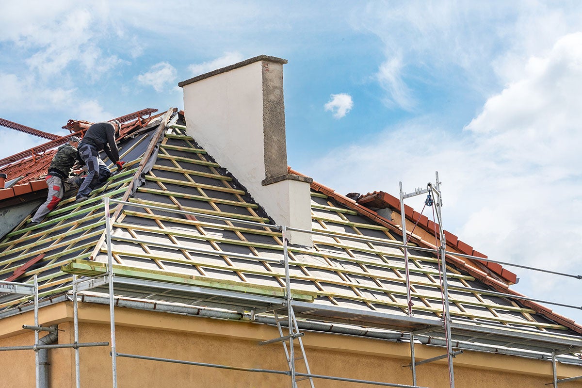 Residential roof under construction with scaffolding and chimney